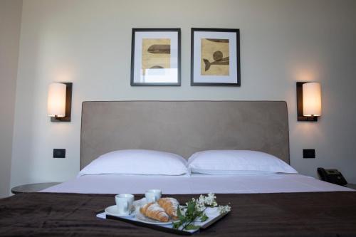 a bed with a tray of bread and drinks on it at DOGANA RESORT in Molfetta