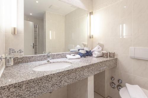 ein Bad mit einem Waschbecken und einem Spiegel in der Unterkunft Appartement - Kleine Auszeit in Binz