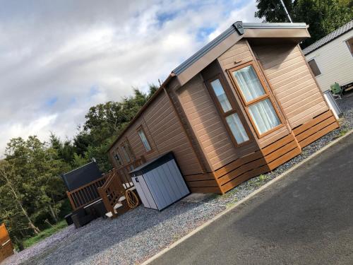 a small cabin with a door on the side of a road at Moonlight Ridge -2 bedroom lodge with hot tub in Felton