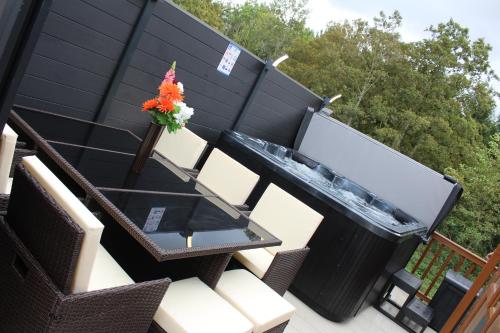 a table and chairs with a vase of flowers on a patio at Moonlight Ridge -2 bedroom lodge with hot tub in Felton