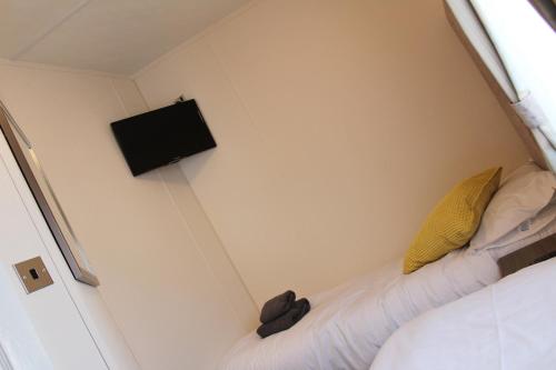 a small room with a bed and a tv on the wall at Moonlight Ridge -2 bedroom lodge with hot tub in Felton