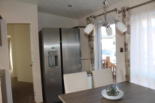 a kitchen with a stainless steel refrigerator and a table at Moonlight Ridge -2 bedroom lodge with hot tub in Felton