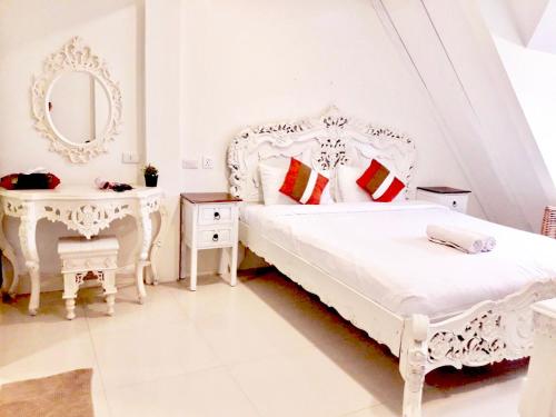 a white bedroom with a white bed and a mirror at 39 Living in Bangkok