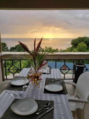 a table with plates and utensils on top of a balcony at Boutique B&B at Stone Village in Bluefields