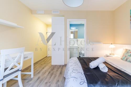 a white bedroom with a bed and a desk at AYZ Villegas - Auto check-in property in Madrid