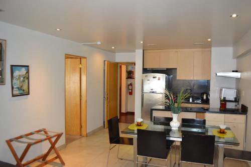 a kitchen and dining room with a table and chairs at Suite Service Apart Hotel in Lima