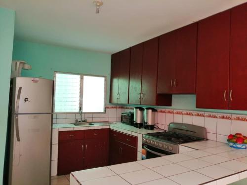 a kitchen with red cabinets and a refrigerator at Green Monkey Hostel in Flores