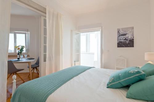 a bedroom with a bed with green pillows and a desk at MyPlaceLisbon - Tágides River View in Lisbon