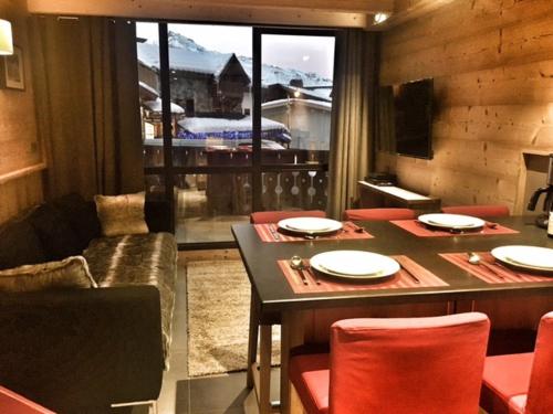 a dining room with a table and chairs and a window at So cosy Val Thorens in Val Thorens