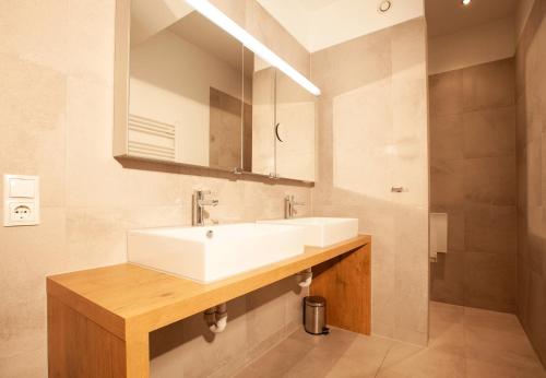 a bathroom with a white sink and a mirror at Apartments Drei Türme by Pferd auf Wolke in Schruns-Tschagguns