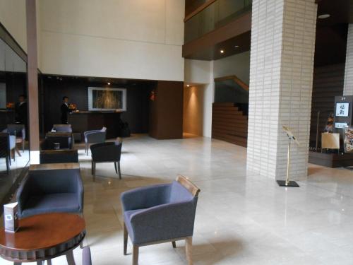 a lobby with chairs and a table in a building at Hotel Bestland in Tsukuba