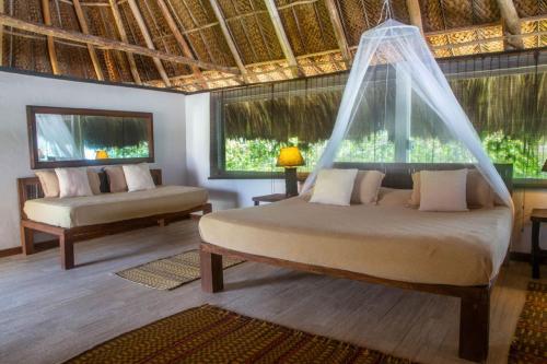 a room with a bed, a chair and a window at Senda Cabaña Barlovento in Los Naranjos