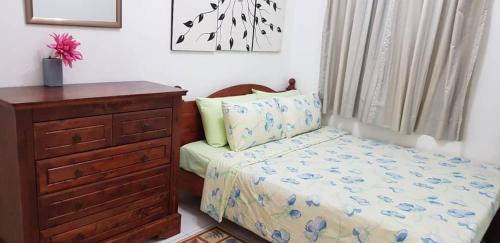 a bedroom with a bed and a dresser at Tun Perak Homestay in Rawang
