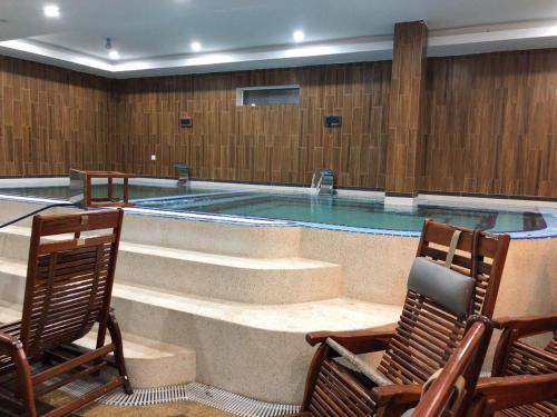 a swimming pool with two chairs and a table at Kampong Thom Royal Hotel in Kompong Thom