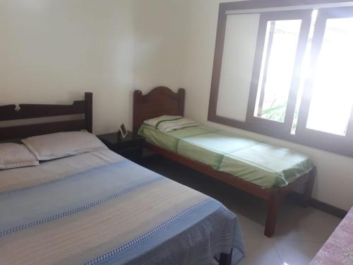 ブジオスにあるCasa Paradiso Temporada em Búziosの窓が2つある部屋にベッドが2つある