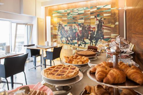 a table topped with different types of pastries and pies at Phi Hotel Palio in Asti