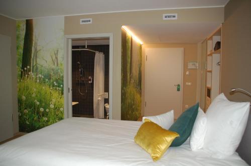 a bedroom with a white bed with a yellow pillow at Péitche Lauer in Useldange