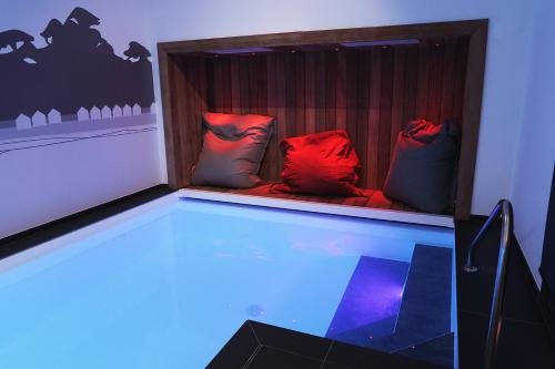 a room with a swimming pool with pillows in a room at La Villa en L'île - 2 Piscines & Spa in Noirmoutier-en-l'lle
