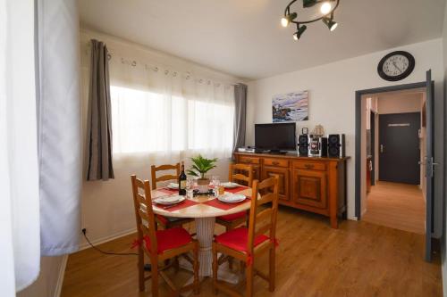 ein Esszimmer mit einem Tisch, Stühlen und einem TV in der Unterkunft Petit appartement douillet très bien situé in Biarritz
