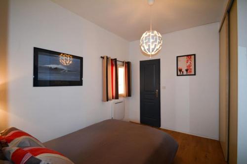 ein Wohnzimmer mit einem Sofa und einem Kronleuchter in der Unterkunft Petit appartement douillet très bien situé in Biarritz