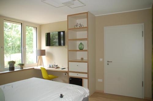 a bedroom with a bed and a desk and a yellow chair at Péitche Lauer in Useldange
