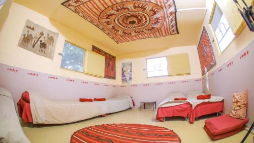 a room with two beds and a ceiling at Negev Camel Ranch in Dimona