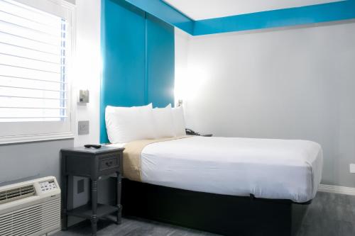 um quarto com uma cama grande e uma parede azul em Tilbury Inn em Glendale