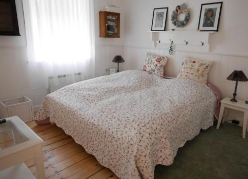 1 dormitorio con 1 cama con edredón blanco y ventana en Beletage en Bølshavn