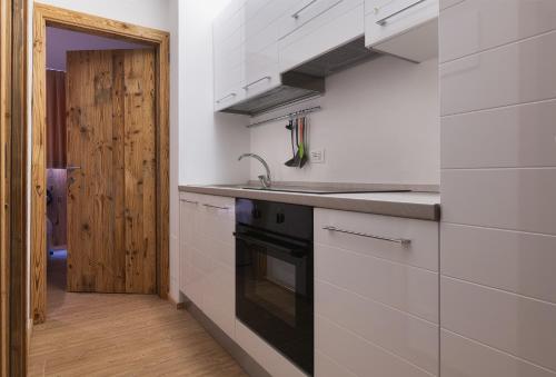 a kitchen with a sink and a stove at Chalet Golf Campiglio / LuxApt / fronte piste-impianti-golf in Madonna di Campiglio