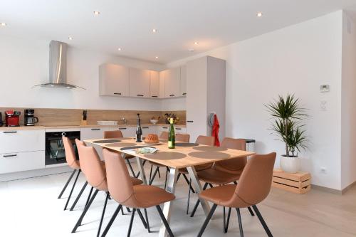 une cuisine et une salle à manger avec une table et des chaises en bois dans l'établissement Gîte de Munt'Z SPA, Sauna, piscine, proche de Colmar, à Muntzenheim