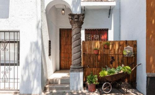 a column in front of a house with a fence at Casa Melgar in Mexico City