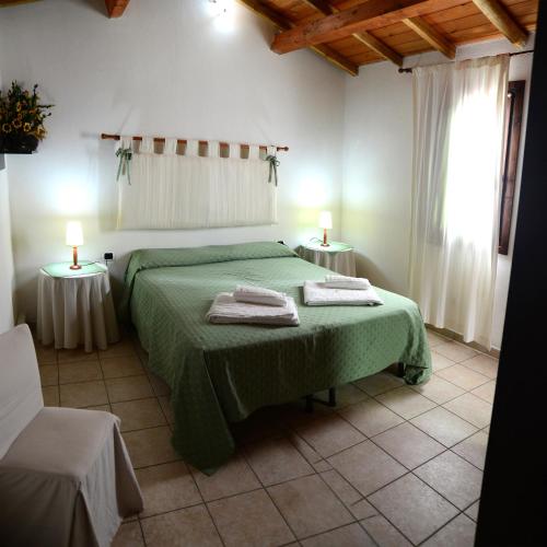a bedroom with a green bed with two tables at Agriturismo Sa Perda Marcada in Arbus