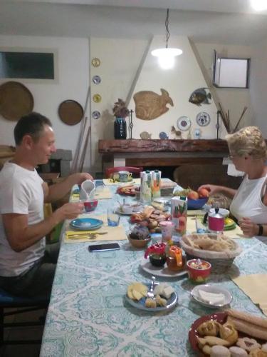 a group of people sitting around a table with food at B&B Valverde in Dorgali
