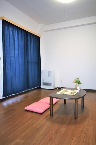 Habitación con mesa y cortina azul en Carid Shiraishi In front of the station / Vacation STAY 4649, en Sapporo