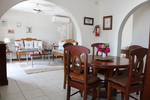 a dining room and living room with a table and chairs at Villa Boscardi in Belize City