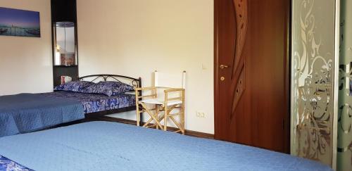 a bedroom with two beds and a chair and a desk at GoraTwins guest house near Boryspil airport in Hora