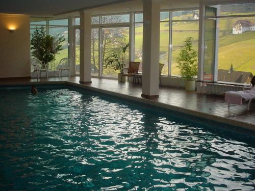 a large swimming pool in a building with windows at Hotel Waldlust in Baiersbronn