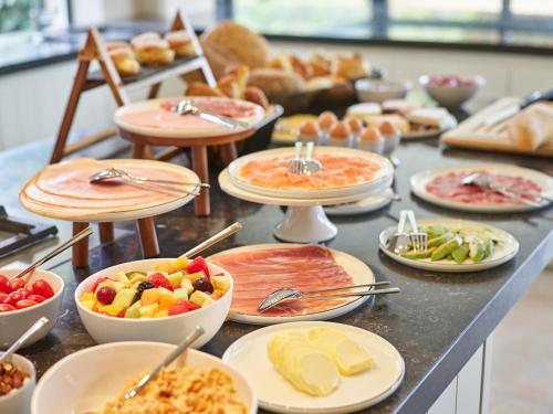 a buffet with many plates of food on a table at Boutique Hotel Ter Wallen in Izegem