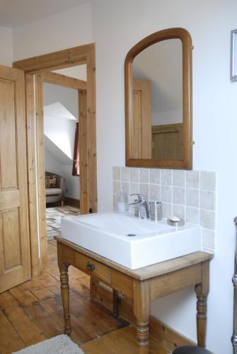 a bathroom with a white sink and a mirror at Seatown Cottage, Lossiemouth in Lossiemouth