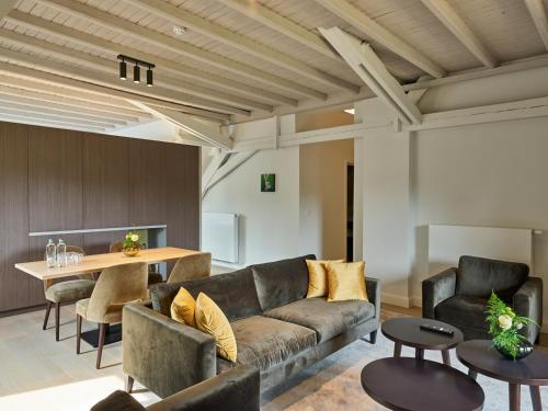 a living room with a couch and a table at Boutique Hotel Ter Wallen in Izegem