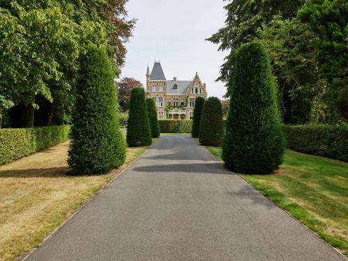 a driveway in front of a house with trees at Boutique Hotel Ter Wallen in Izegem