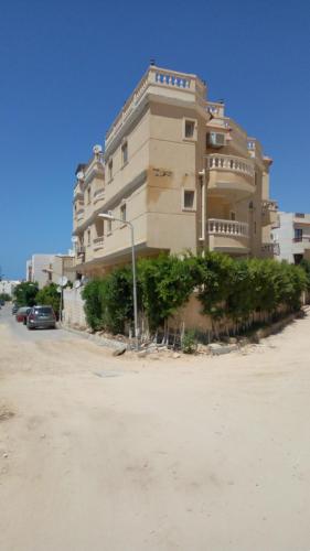 a large building with a car parked in front of it at شاليه عايدة بيتش للعائلات فقط in El Alamein