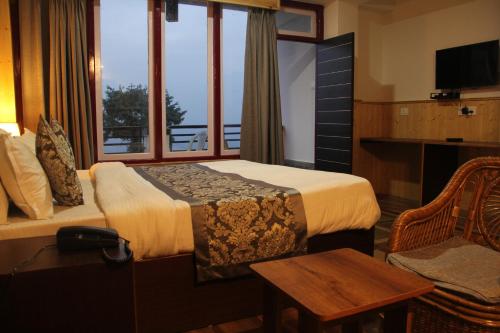 a hotel room with a bed and a window at BluBen Alpine in Pelling
