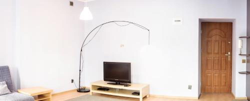 a living room with a flat screen tv on a table at Marszałkowska Apartment in Warsaw