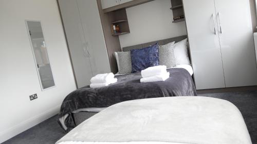 a bedroom with two beds with towels on them at The Hatton Rooms in New Bedfont