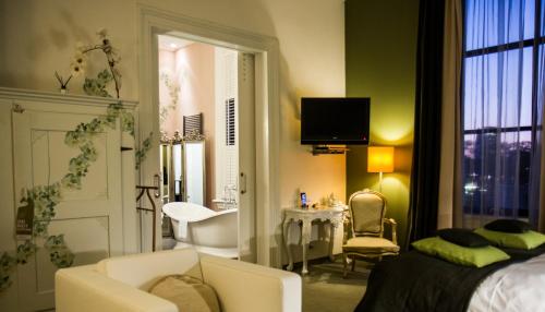 a bedroom with a bed and a bathroom with a sink at Suitehotel Pincoffs in Rotterdam