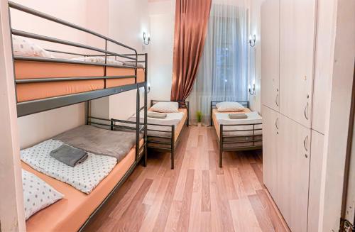 a room with three bunk beds and a hallway at Hostel u Kmity in Krakow