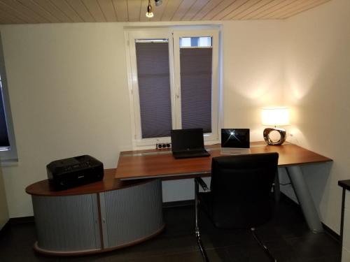 an office with a desk with two laptops on it at 3 Doppelbett Business Apartment am Bodensee in Arbon