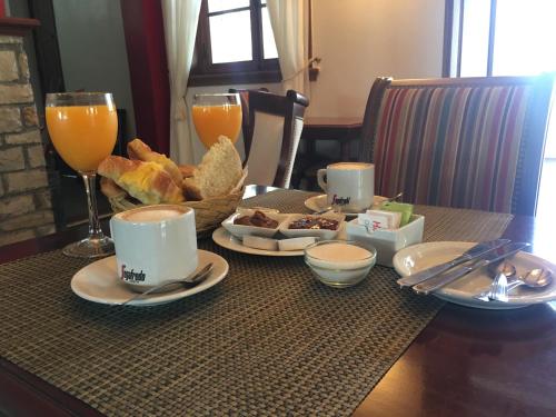 un tavolo con colazione a base di pane e succo d'arancia di Hotel Cerros a Rosario de Lerma