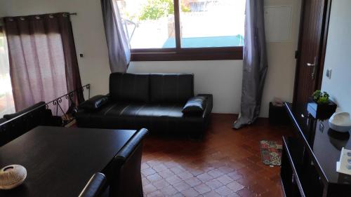 a living room with a black leather couch and a table at Louro's Villa - 12130AL in Cantanhede